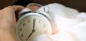 Person hitting an alarm clock