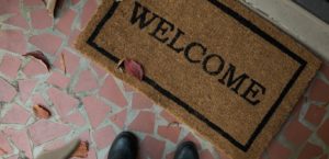 Person looking down at welcome mat
