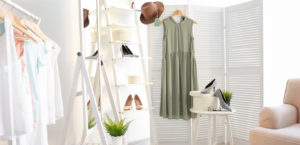 A light and bright boutique setting with shoes, a dress, and hat.