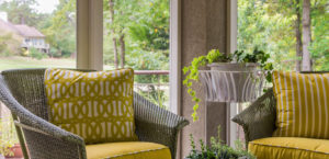 Cheerful yellow outdoor furniture chairs on a screened in porch.