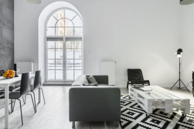 East coast style loft and modern interior design with black and white colorway patterened rug and feature wall.