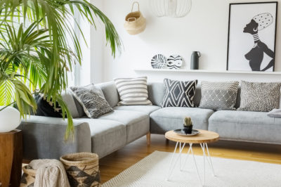 Modern boho aesthetic living room with netural colorways and patterned pillows large faux plant