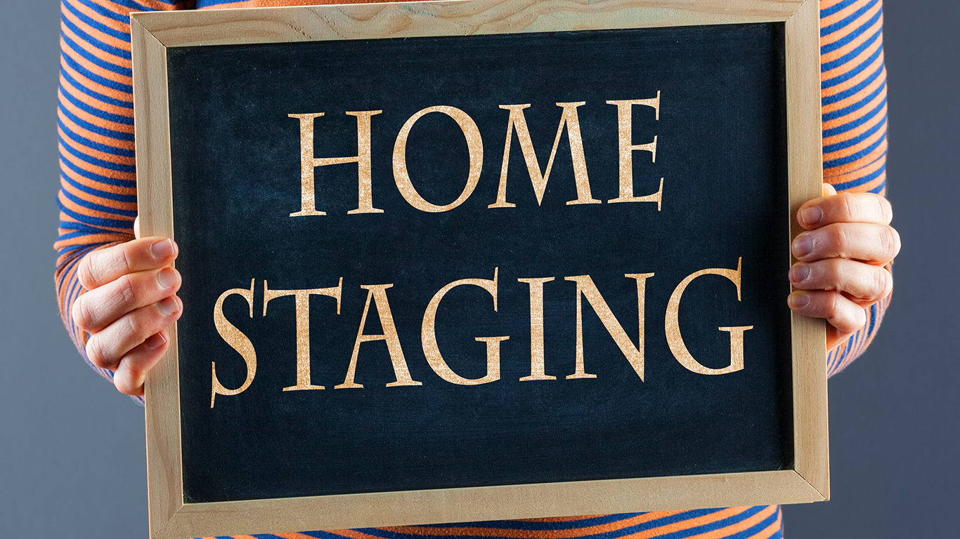 Woman holding chalkboard sign that reads "home staging"