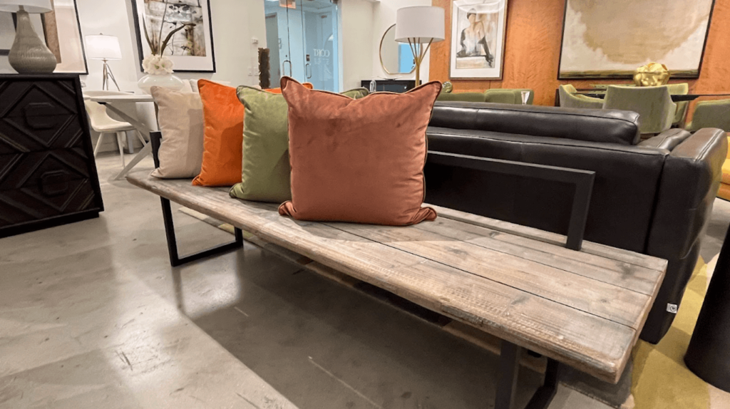 Colorful throw pillows lined up on a bench.