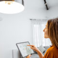 Woman adjusting her lights with a smart lightbulb and app.