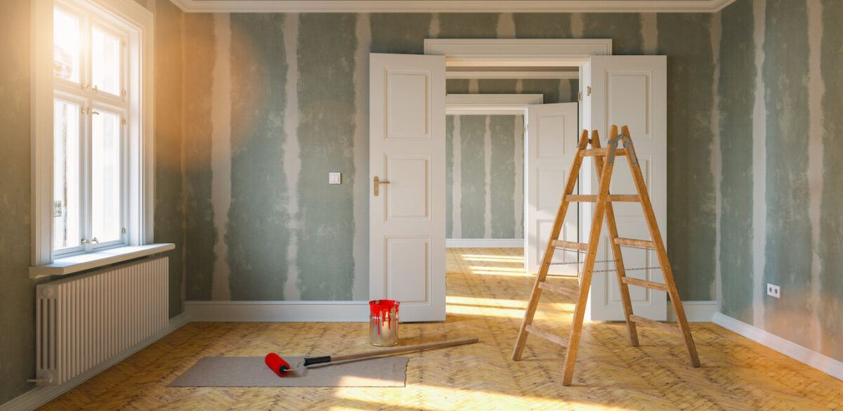 An empty house shown mid-remodel with a ladder in the center of the room.