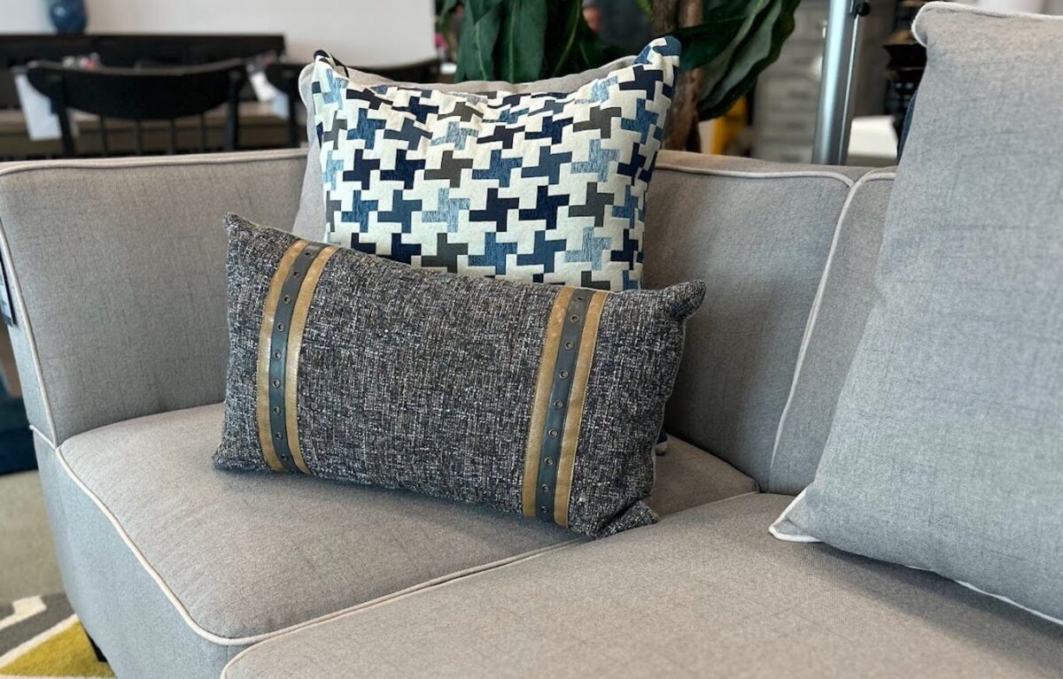 A grey sofa styled with black and white throw pillows.