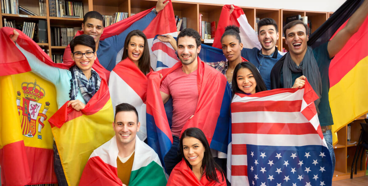 A diverse group of college students holding the flags of their countries.