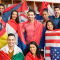 A diverse group of college students holding the flags of their countries.