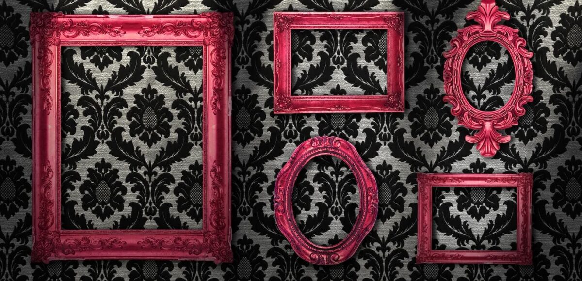 Black and white vintage wallpaper with bright pink picture frames.