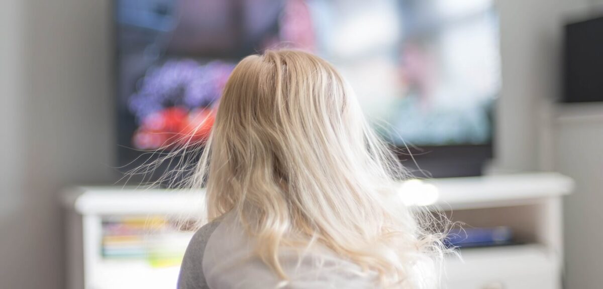 A child watching TV, their hair standing up with static electricity.