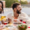 A group of friends eat dinner together outdoors.