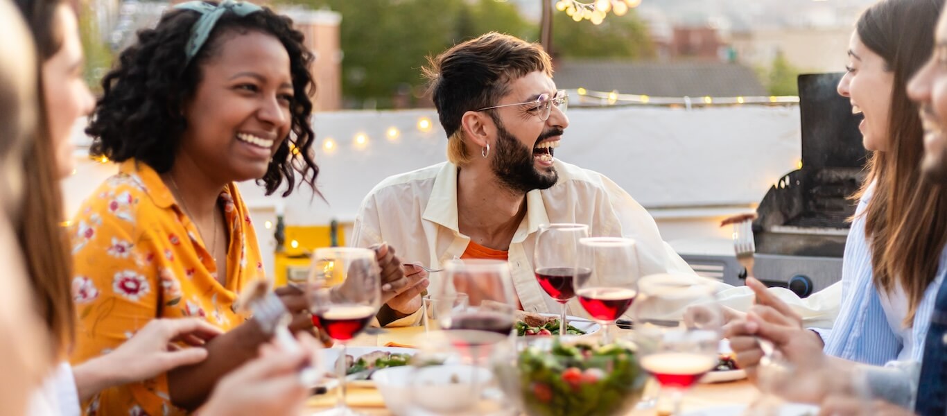 A group of friends eat dinner together outdoors.