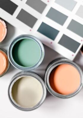 assortment of paint cans in trendy colors for budget friendly decorating tips and low cost interior design trends 2025
