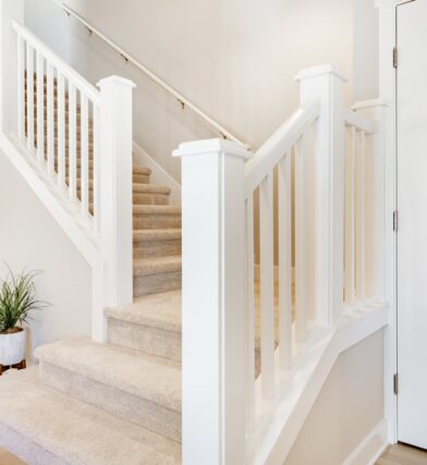 Beige and tan stair landing with potted plants for folks wondering how to decorate stair landing and how to decorate stairs