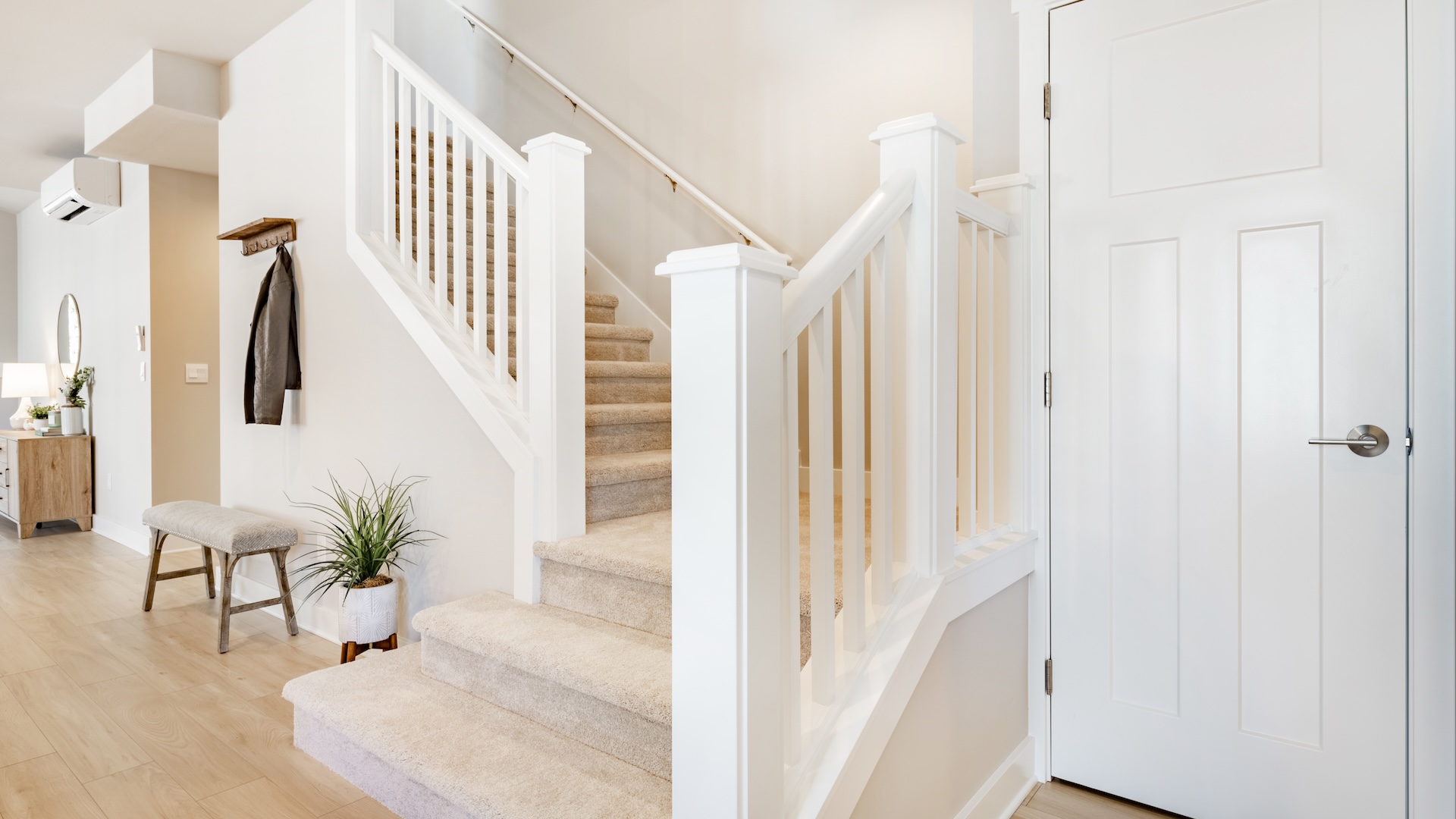 Beige and tan stair landing with potted plants for folks wondering how to decorate stair landing and how to decorate stairs