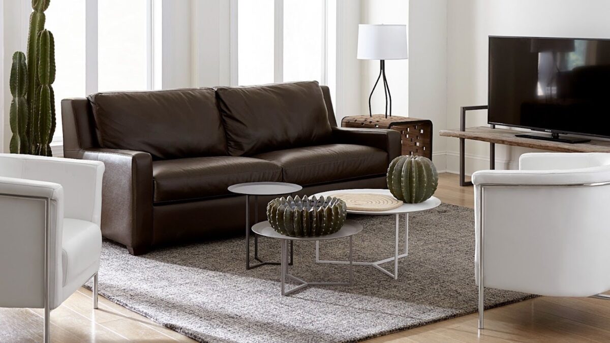 Luxurious living room with leather couch and accent pieces demonstrating decorating with metal. Follow CORT Furniture Outlet's tips for decorating with metal to learn how to mix metals in home design.
