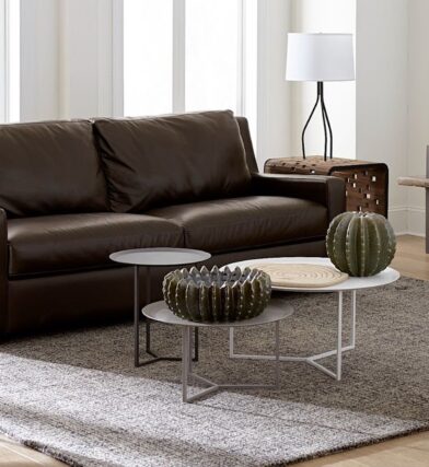 Luxurious living room with leather couch and accent pieces demonstrating decorating with metal. Follow CORT Furniture Outlet's tips for decorating with metal to learn how to mix metals in home design.