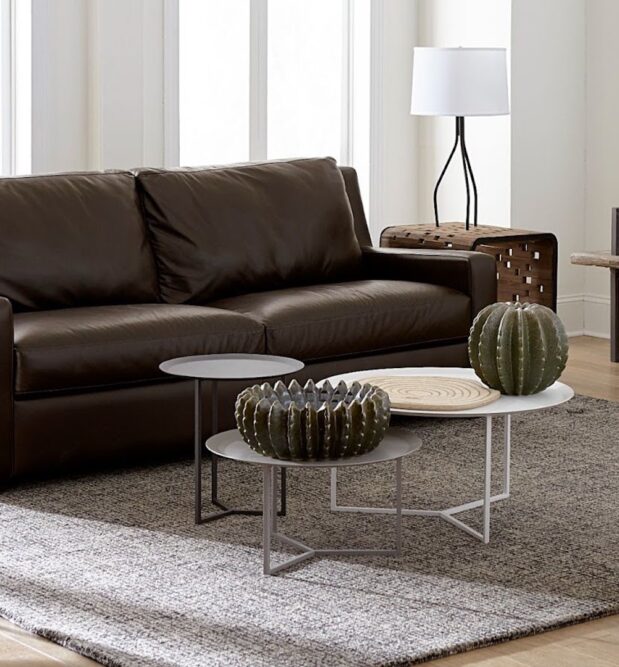 Luxurious living room with leather couch and accent pieces demonstrating decorating with metal. Follow CORT Furniture Outlet's tips for decorating with metal to learn how to mix metals in home design.