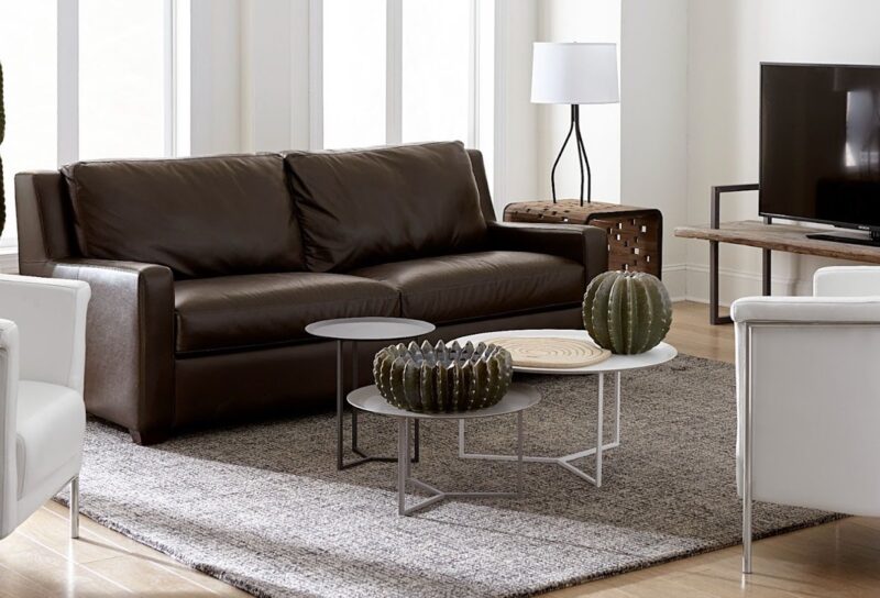 Luxurious living room with leather couch and accent pieces demonstrating decorating with metal. Follow CORT Furniture Outlet's tips for decorating with metal to learn how to mix metals in home design.